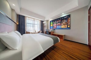 Ein Hotelzimmer mit einem großen Bett, einem Schreibtisch, einem an der Wand befestigten Fernseher und einem Fenster mit Vorhängen.
