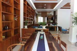 A room with a long wooden table, chairs, a bookshelf, and a dining area. - Bishan Banshe Holiday Villa (Xianju)