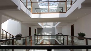 A modern interior with a glass atrium, a staircase, and a view of the outside. - Bishan Banshe Holiday Villa (Xianju)