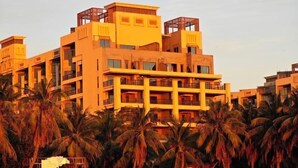 A multi-story hotel with balconies and a flat roof design, surrounded by palm trees. - Qjia Ledong Xiangrui Seaview Business Hotel (Longmuwan Branch) (Ledong)