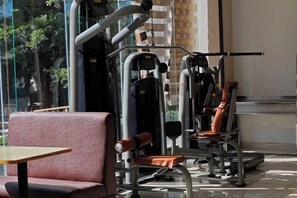 A gym with exercise machines, a seating area, and a large window.