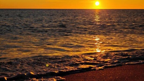 A sunset over the ocean with a beach in the foreground. - Qjia Ledong Xiangrui Seaview Business Hotel (Longmuwan Branch) (Ledong)