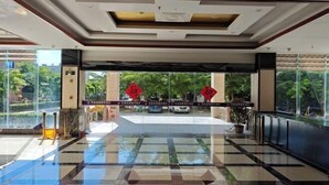 A spacious lobby with a polished floor, large windows, and a view of the outdoors. - Qjia Ledong Xiangrui Seaview Business Hotel (Longmuwan Branch) (Ledong)