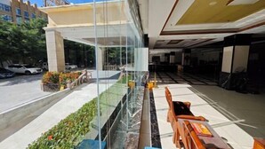 A modern hotel lobby with a glass barrier, seating area, and a view of the street. - Qjia Ledong Xiangrui Seaview Business Hotel (Longmuwan Branch) (Ledong)