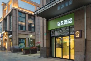 A hotel entrance with a green sign, a glass door, and a visible parking sign. - Hi Inn (Shanghai Jiuting Subway Station) (Shanghai)