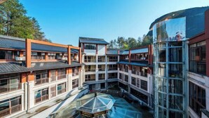A multi-story building with a central courtyard, large windows, and a glass atrium. - Dragon Tiger Villa (Guixi)