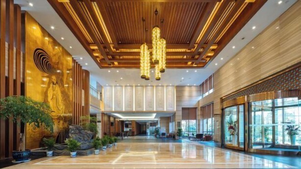 A spacious lobby with a polished floor, wooden ceiling panels, and a large chandelier. - Dragon Tiger Villa (Guixi)