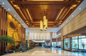 A spacious lobby with a polished floor, wooden ceiling panels, and a large chandelier. - Dragon Tiger Villa (Guixi)
