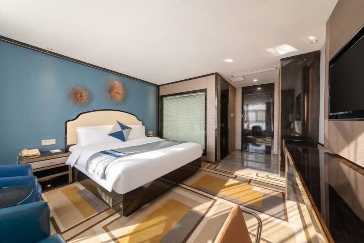 Une chambre d’hôtel moderne dotée d’un grand lit, d’un téléviseur à écran plat et d’un petit coin salon.