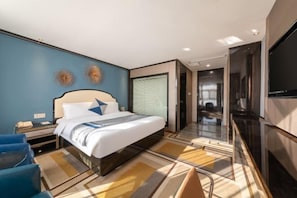 Une chambre d’hôtel moderne dotée d’un grand lit, d’un téléviseur à écran plat et d’un petit coin salon.