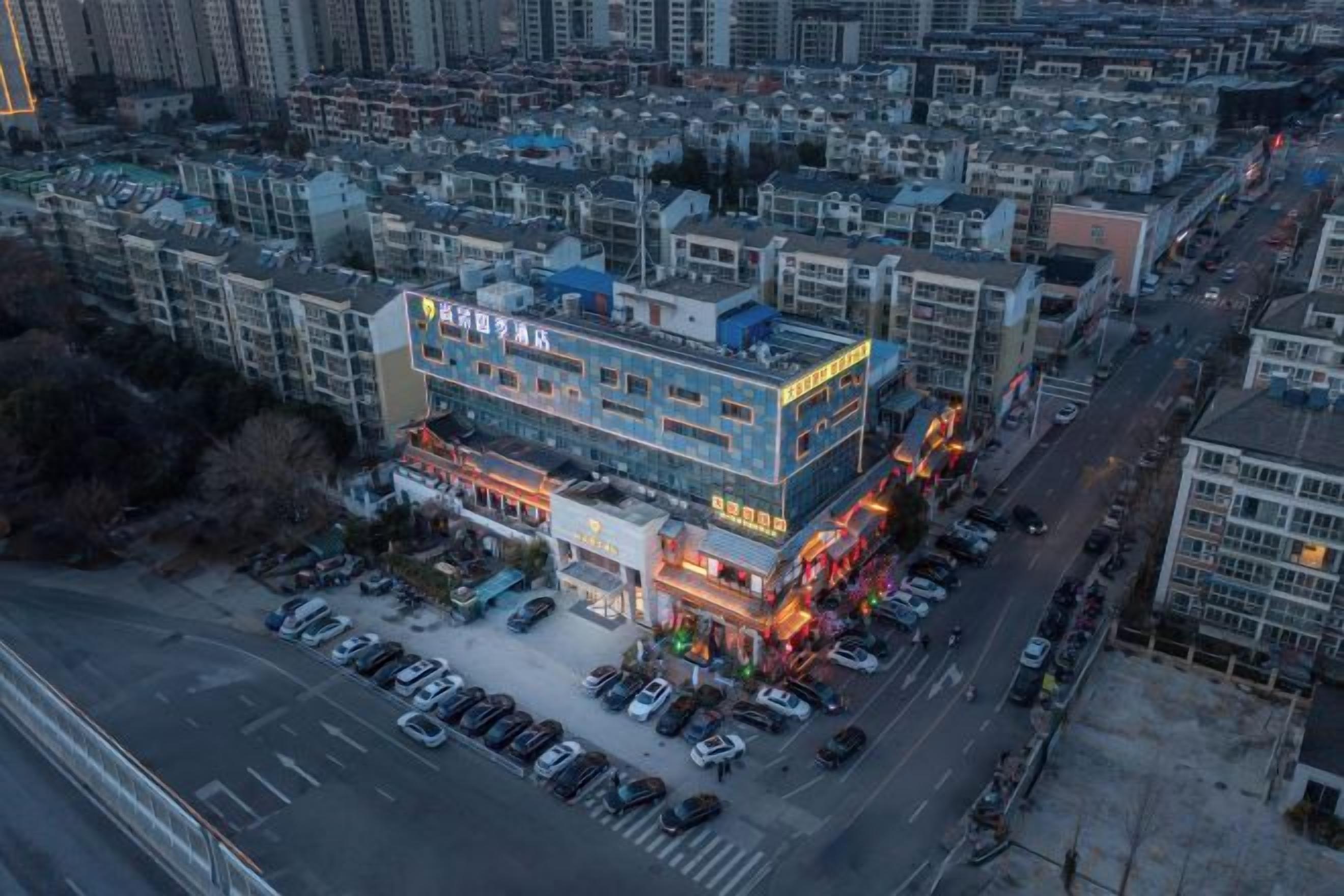 Un immeuble à plusieurs étages, avec un parking à l  ’avant, entouré d’autres bâtiments.