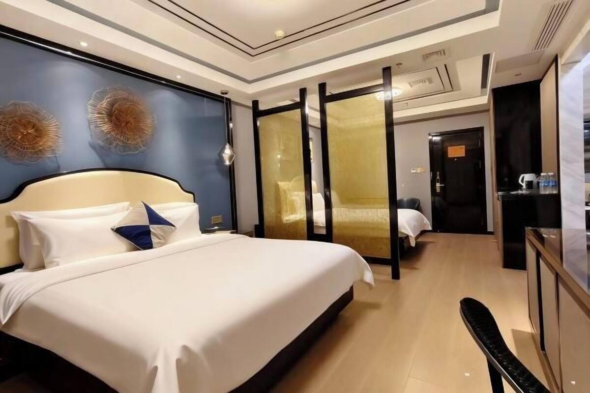 Une chambre d’hôtel avec un grand lit, un bureau et un dressing.