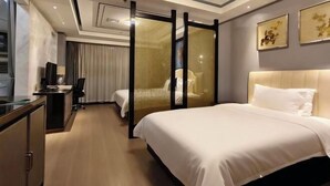 A hotel room with a bed, a desk, a chair, a television, and a sliding door. - Shangjing Full Seasons Hotel (Xuzhou)