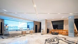 A modern lobby with a reception desk, seating area, and a large window offering a view. - Shangjing Full Seasons Hotel (Xuzhou)
