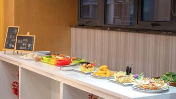 A buffet with various dishes and a chalkboard menu.