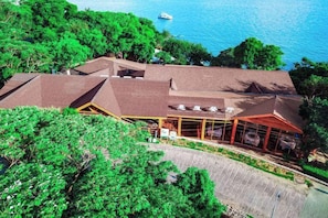 A building with a sloped roof, large windows, and a view of the sea. - Luzui Hotel (Shenzhen)