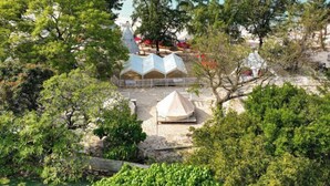 A beachside area with tents and trees. - Luzui Hotel (Shenzhen)