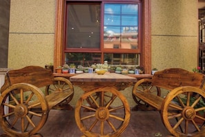 Une table en bois avec quatre chaises, une fenêtre donnant sur un beau paysage et des plantes en pot sur le rebord de la fenêtre.
