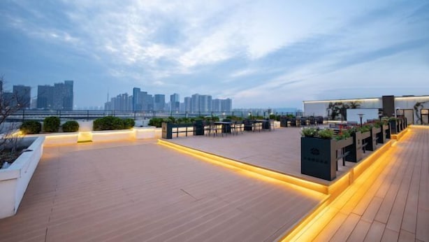 A rooftop terrace with wooden flooring, seating areas, and planters. - Iu Hotel Zhengzhou Science Avenue Zhengzhou University (Zhengzhou)