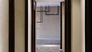 A hallway with a modern design, featuring a geometric light fixture and a stone floor. - Tongli Cloud House Quadrangle Designer Cinema Hotel (Suzhou)