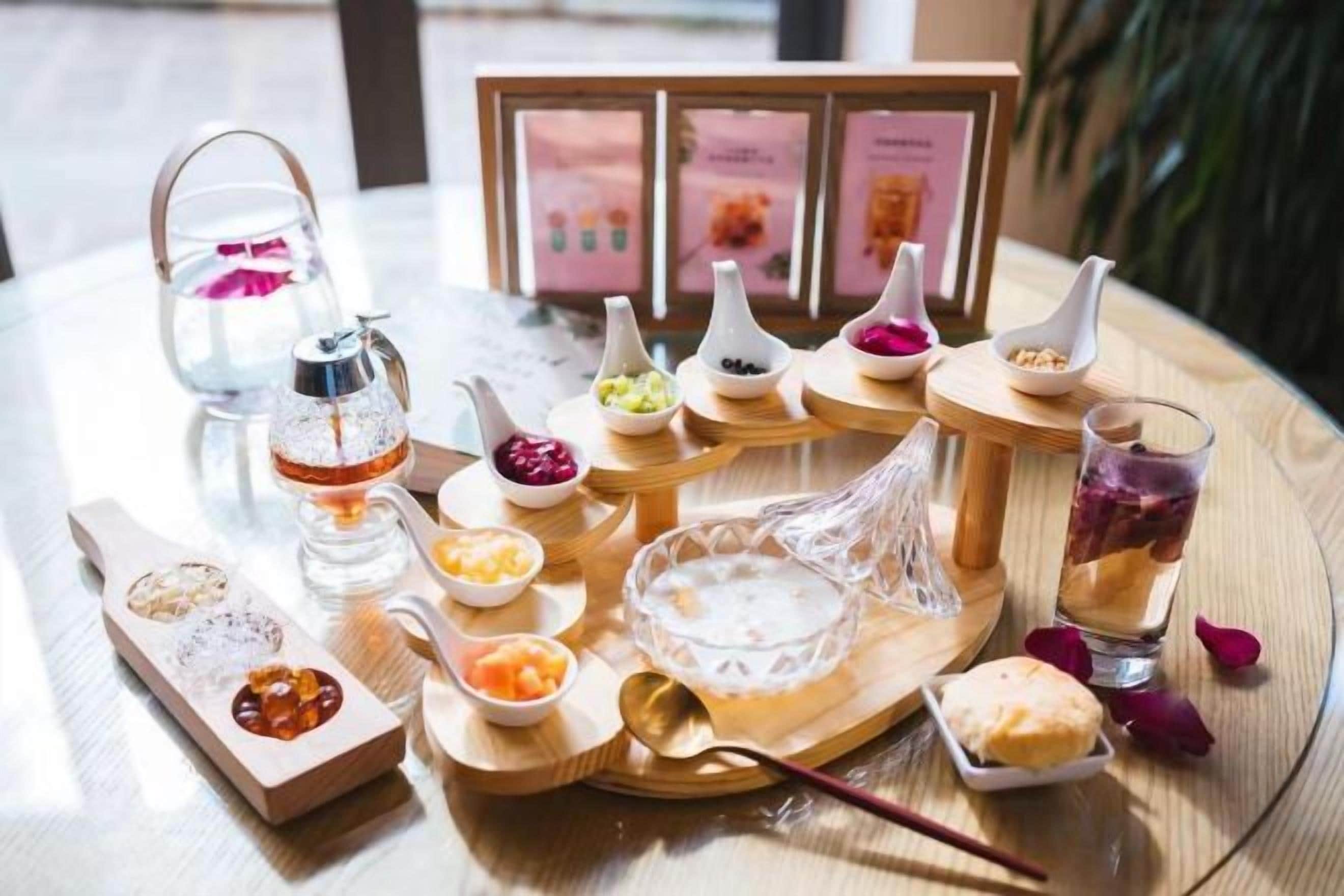 Una mesa con diferentes alimentos y un juego de té, incluyendo una tetera y tazas.