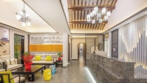 A hotel lobby with a reception desk, seating area, and a decorative wall with text. - Tongli Cloud House Quadrangle Designer Cinema Hotel (Suzhou)