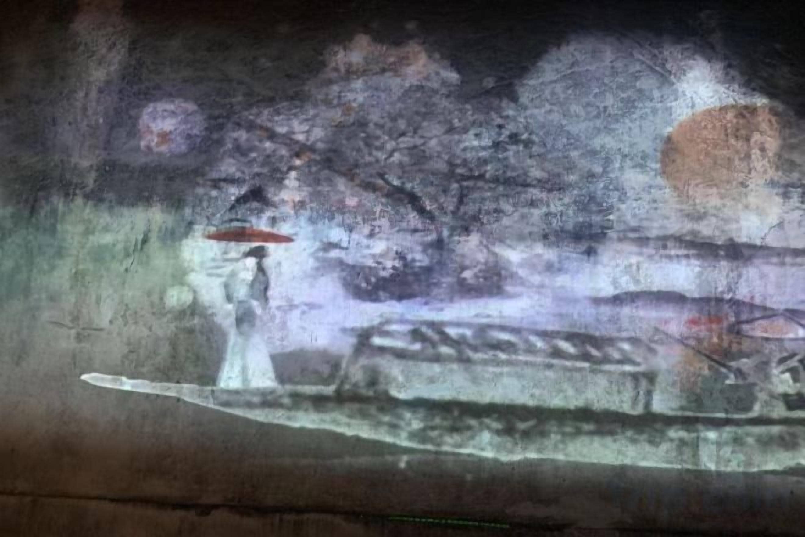 A wall with a mural depicting a person in a white dress holding a red umbrella.