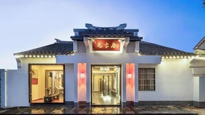 A traditional building with a sign that reads "Inn of the Gods" and a tiled roof. - Tongli Cloud House Quadrangle Designer Cinema Hotel (Suzhou)