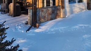A rustic cabin with a stone foundation, wooden exterior, and a covered porch area. - Rustic elegance (St Malo)