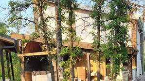 A rustic cabin with a wooden deck, surrounded by trees and a grassy yard. - Rustic elegance (St Malo)