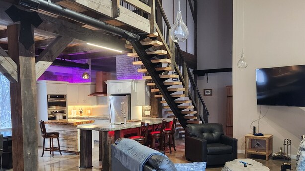 A spacious living area with a modern kitchen, a staircase, and a cozy seating area. - Rustic elegance (St Malo)