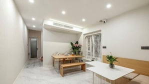 Ein modernes Interieur mit einem weißen Tisch, einer Bank und einem Blumentopf.