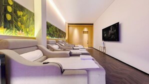 A spa room with multiple massage chairs, a large wall mural, and a framed artwork on the wall. - Blossom Seasons Club (Beijing)