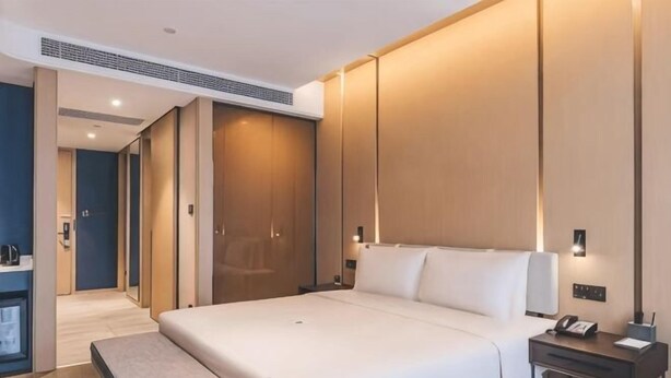 A modern hotel room with a large bed, bedside tables, a bench, and a wardrobe. - Kate Hotel (Guangzhou Dadao Yangxu Metro Station) (Guangzhou)
