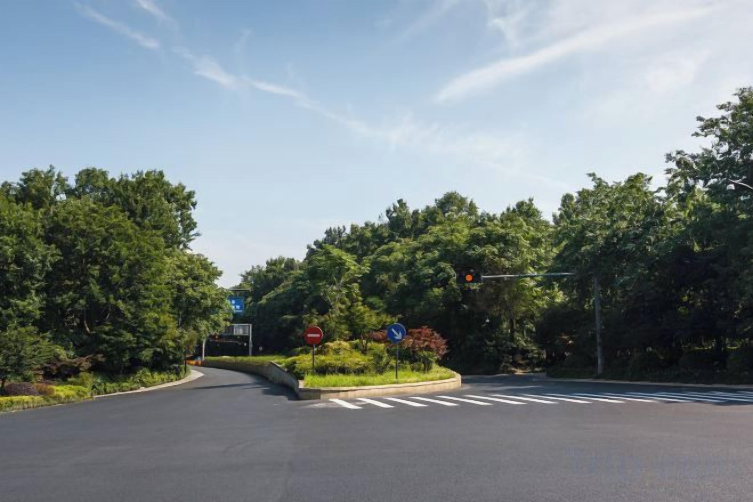 A road intersection with traffic lights and directional signs.