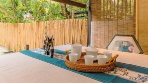A room with a bed, a bamboo fence, and a table with cups and a decorative figure. - Hangzhou Lanyu Maitian Inn (Xihu Lingyin Branch) (Hangzhou)