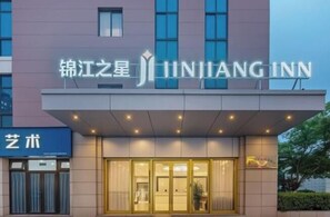 A hotel with a modern facade, a prominent sign for 'JINJIANG INN,' and a visible entrance with glass doors. - Jinjiang-Inn Fengshang Wuxi Yuqi Huxi Road Hotal (Wuxi)