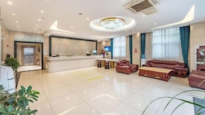 Una hall d'albergo con reception, area salotto e lampadario.