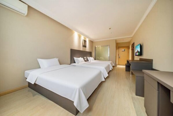 A hotel room with two beds, a desk, and a TV. - Jinjiang-Inn Fengshang Wuxi Yuqi Huxi Road Hotal (Wuxi)