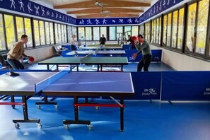 A table tennis facility with multiple tables and players. - Yujing Garden Holiday Hotel (Shijiazhuang)