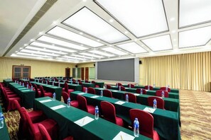 A conference room with rows of tables, chairs, and a projector screen. - Yujing Garden Holiday Hotel (Shijiazhuang)