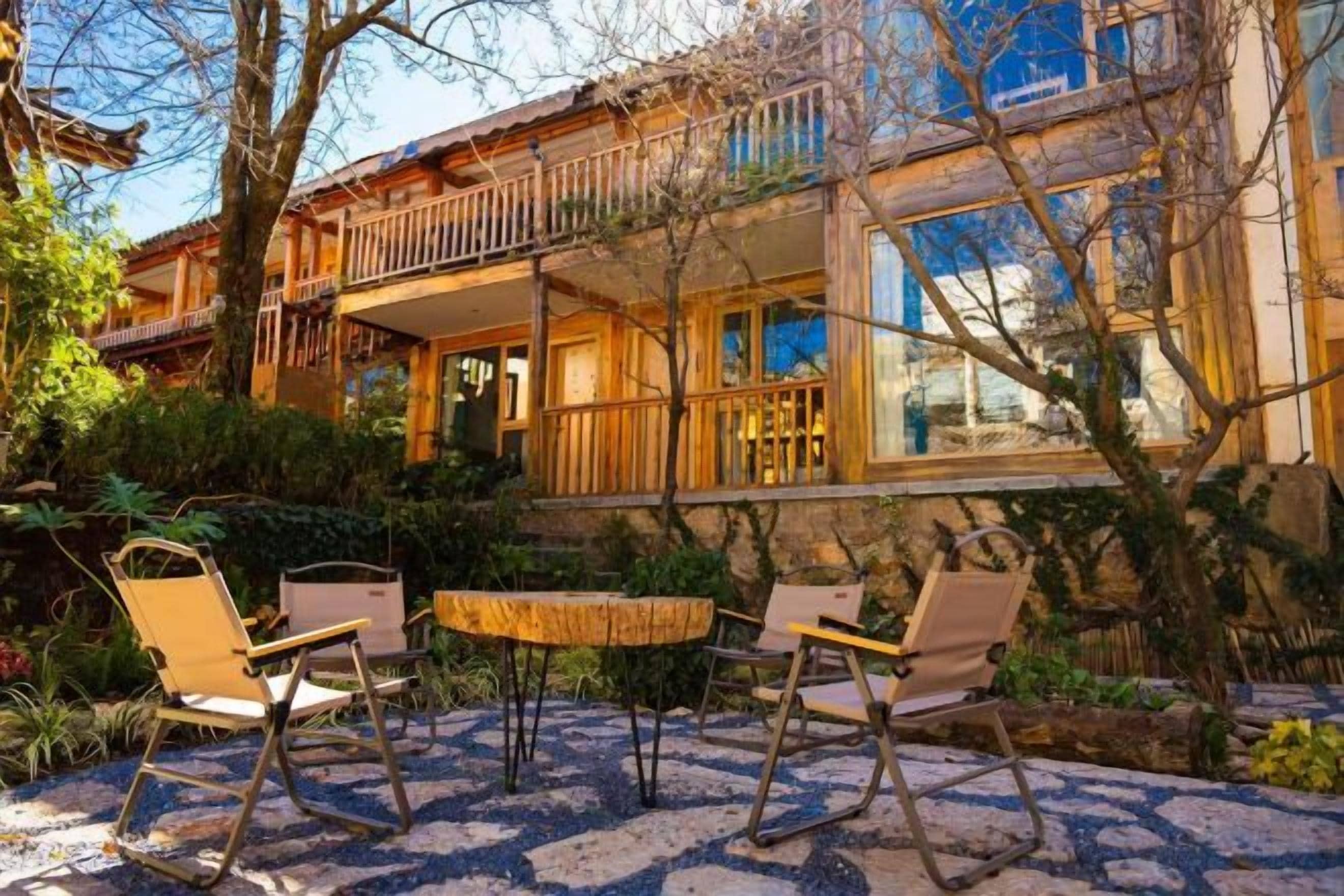 A wooden house with a balcony, outdoor seating, and a garden.