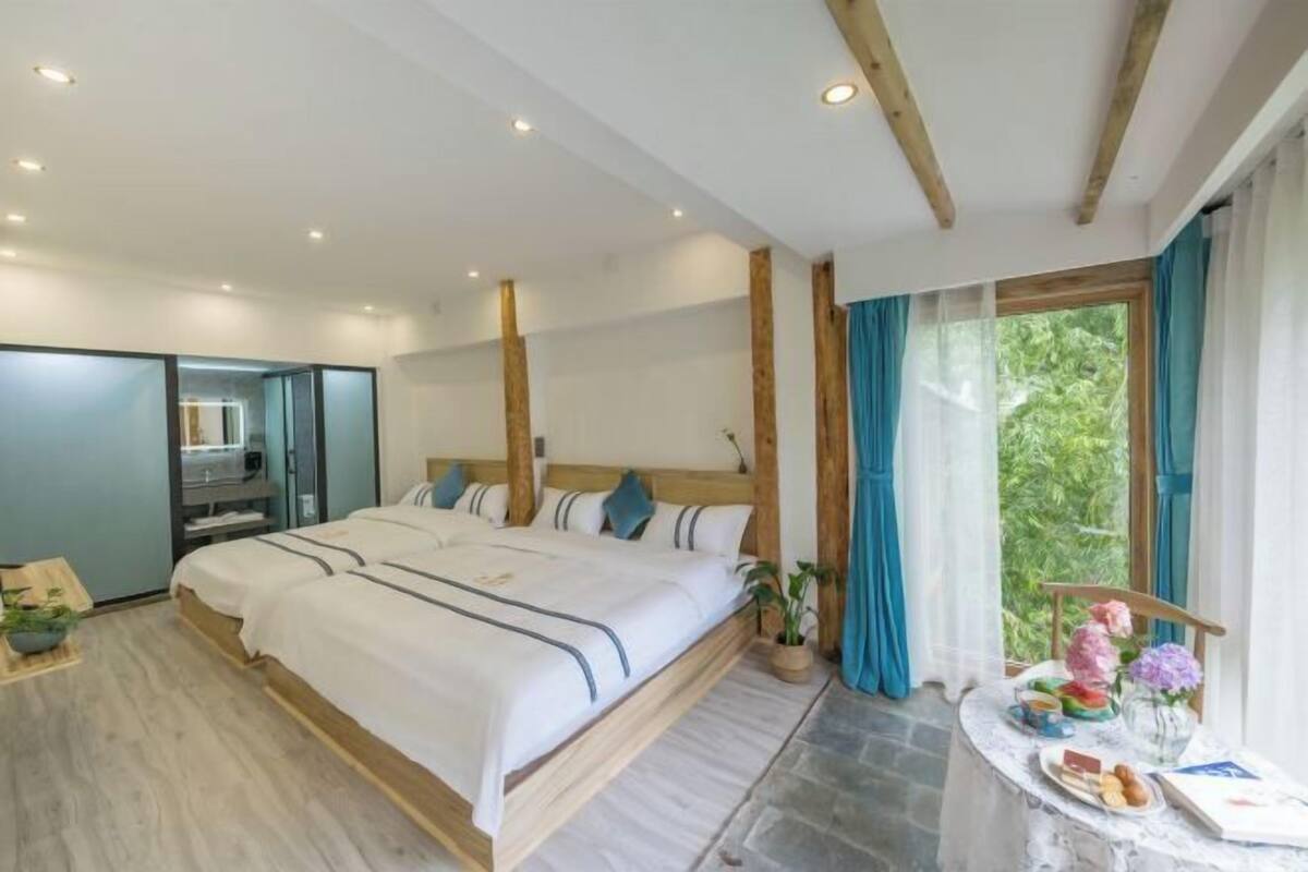 Ein Schlafzimmer mit einem großen Bett, einem Schreibtisch und einem Fenster mit Vorhängen.
