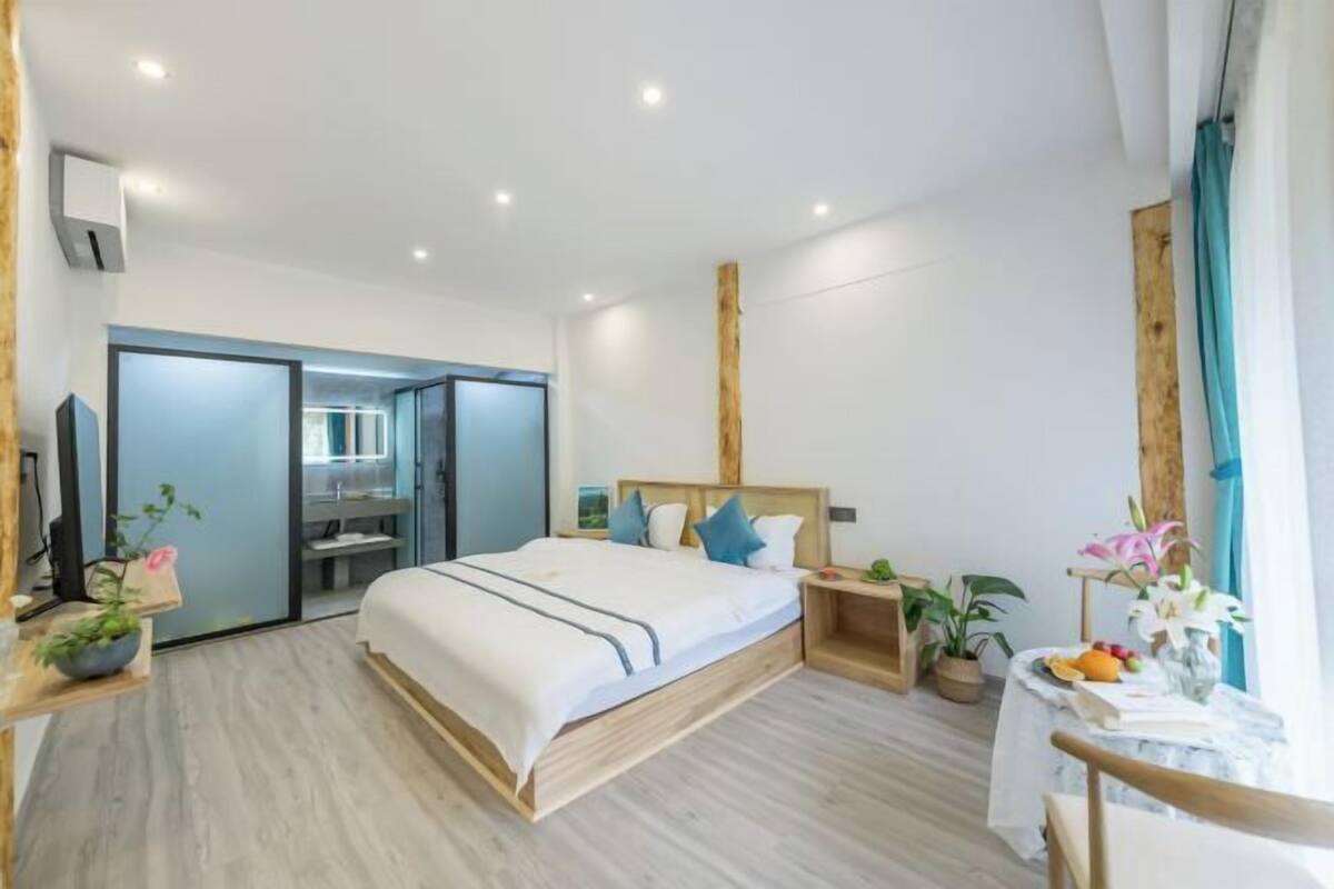 Ein modernes Hotelzimmer mit Bett, Nachttischen, Schreibtisch und Stuhl.