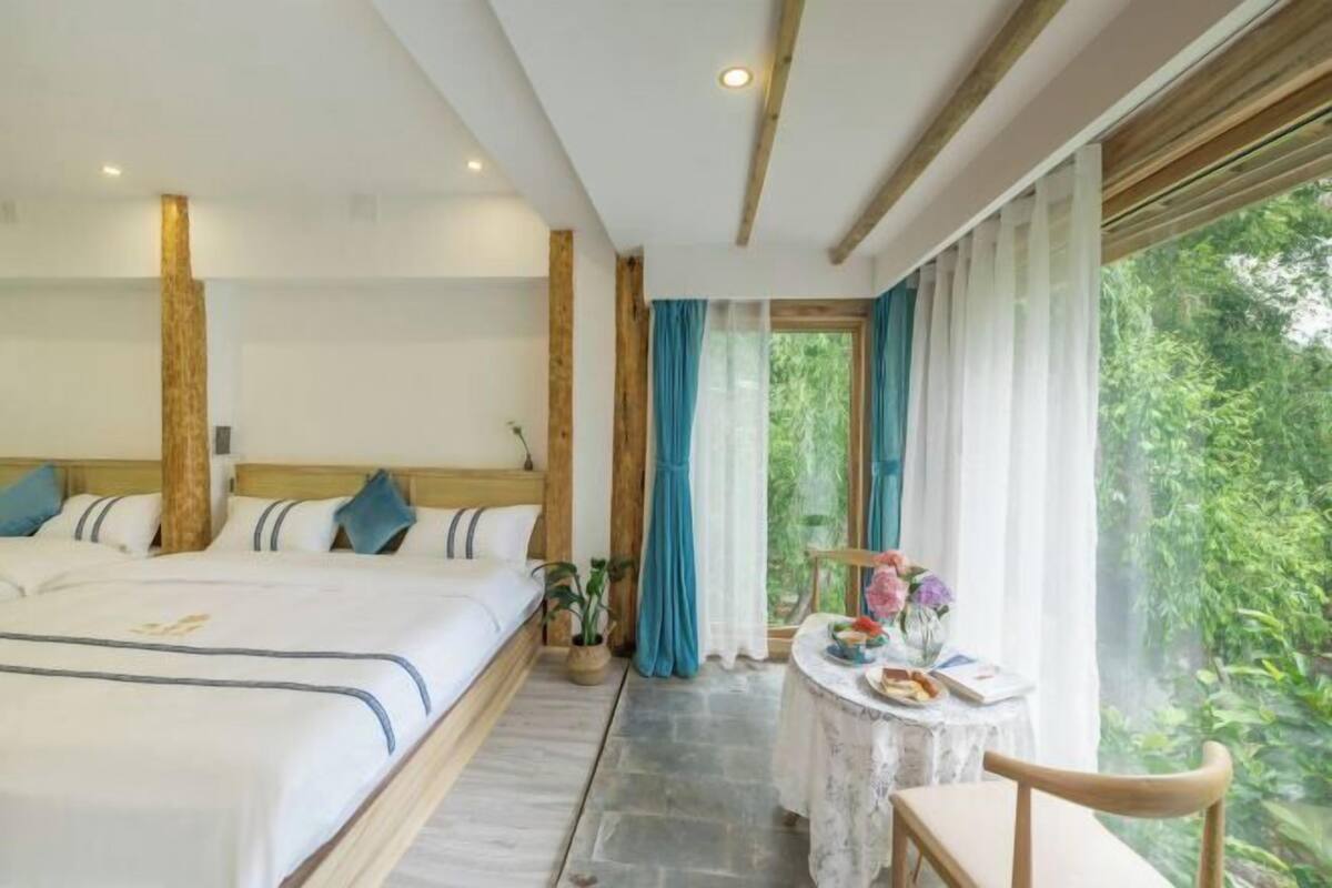 Ein Schlafzimmer mit einem Bett, einem kleinen Tisch und einem Stuhl.