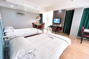 Een hotelkamer met twee bedden, een bureau met een televisie, een eettafel en een stoel.