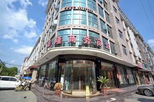 Un hotel de varios pisos con fachada curva y señalización en un idioma extranjero.