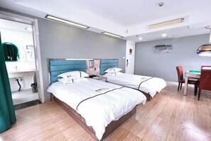 Een hotelkamer met twee bedden, een bureau en een stoel.