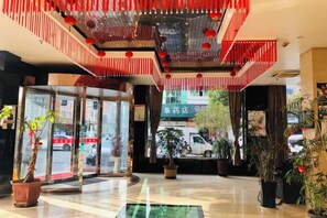 A hotel lobby with a glass entrance, potted plants, and a red decorative ceiling. - Linhai Tailong Business Hotel (Duqiao Babylong Plaza) (Linhai)