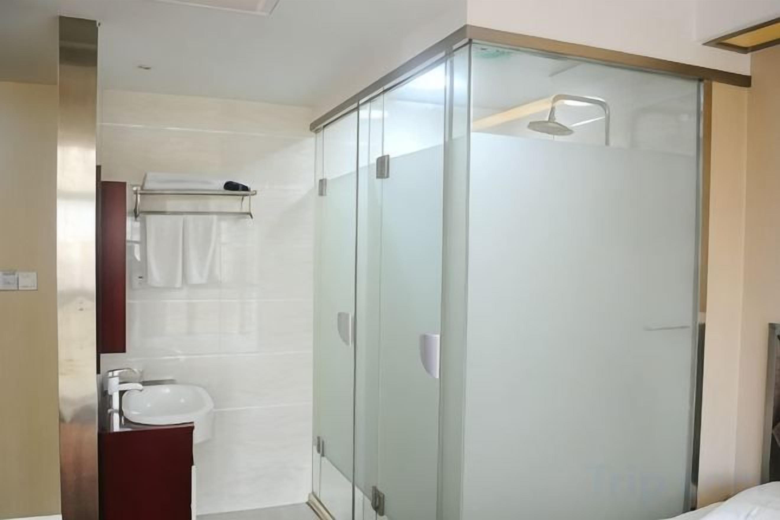 A modern bathroom with a glass-enclosed shower, a sink, and a mirror.